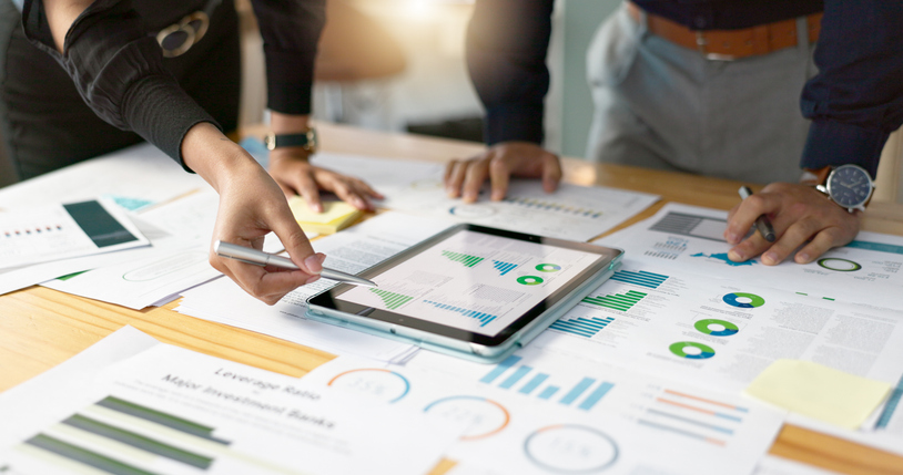 commercial real estate portfolio management conducted with data analysis, tablet, and related paperwork